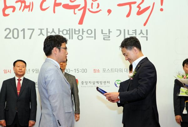 윤한덕 중앙응급의료센터 센터장<사진 왼쪽>이 박능후 보건복지부 장관으로부터 수상을 하고 있다.