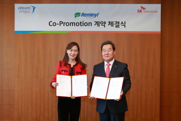 전광현 SK케미칼 LS biz 사장(오른쪽)이 제니정 한국얀센 사장과 치매 치료제 '레미닐' 판매계약을 체결하고 있다.