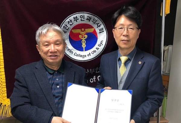 고상덕 선거관리위원장(왼쪽)에게 당선증을 받고 있는 김동석 회장(오른쪽)