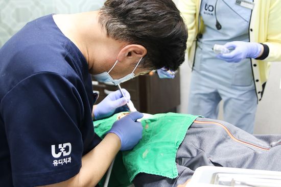 유디계산치과의원 대표원장이 박 모군(12세)을 진료하고 있는 모습. 사진 제공: 유디치과