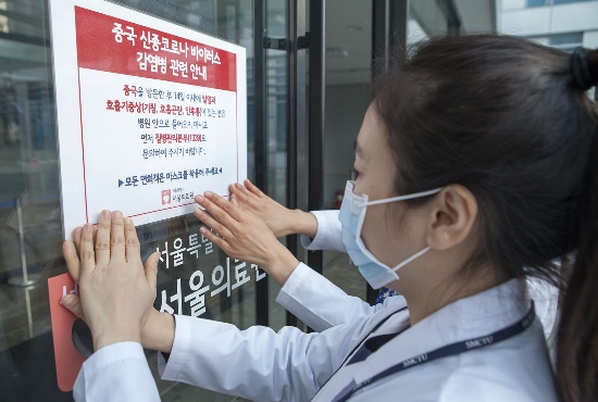 서울의료원 관계자들이 병원 출입문에 신종 코로나바이러스 관련 안내문을 부착하고 있다. 사진은 기사 내용과 직접 관련이 없습니다. 
