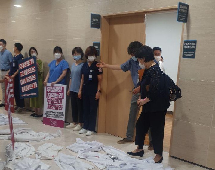 대구 계명대병원 교수들이 복도에 의사 가운을 깔아놓고 보건복지부 실사단에 항의하는 모습.