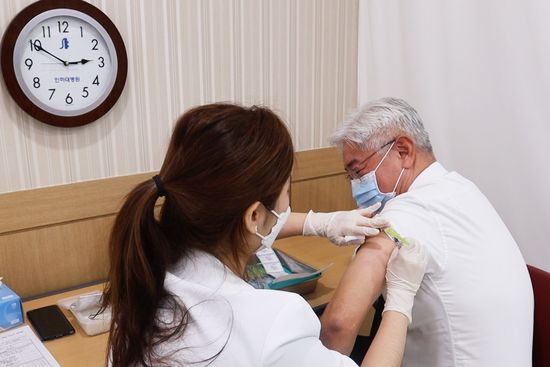 - 인하대병원 김영모 병원장(사진 오른쪽)이 8일 오후 2시 50분께 화이자 백신을 접종하고 있다. 사진 제공: 인하대병원