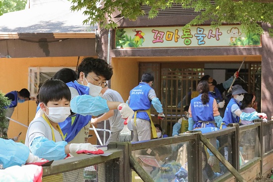 지난 6월 동아제약 임직원 가족들이 세이브투세이브 캠페인 일환으로 서울대공원 동물원 벽화 그리기 자원봉사 활동을 하고 있다.